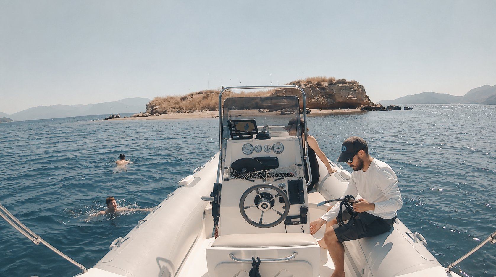 Guests swimming beside the RIB next to a small sandy islet