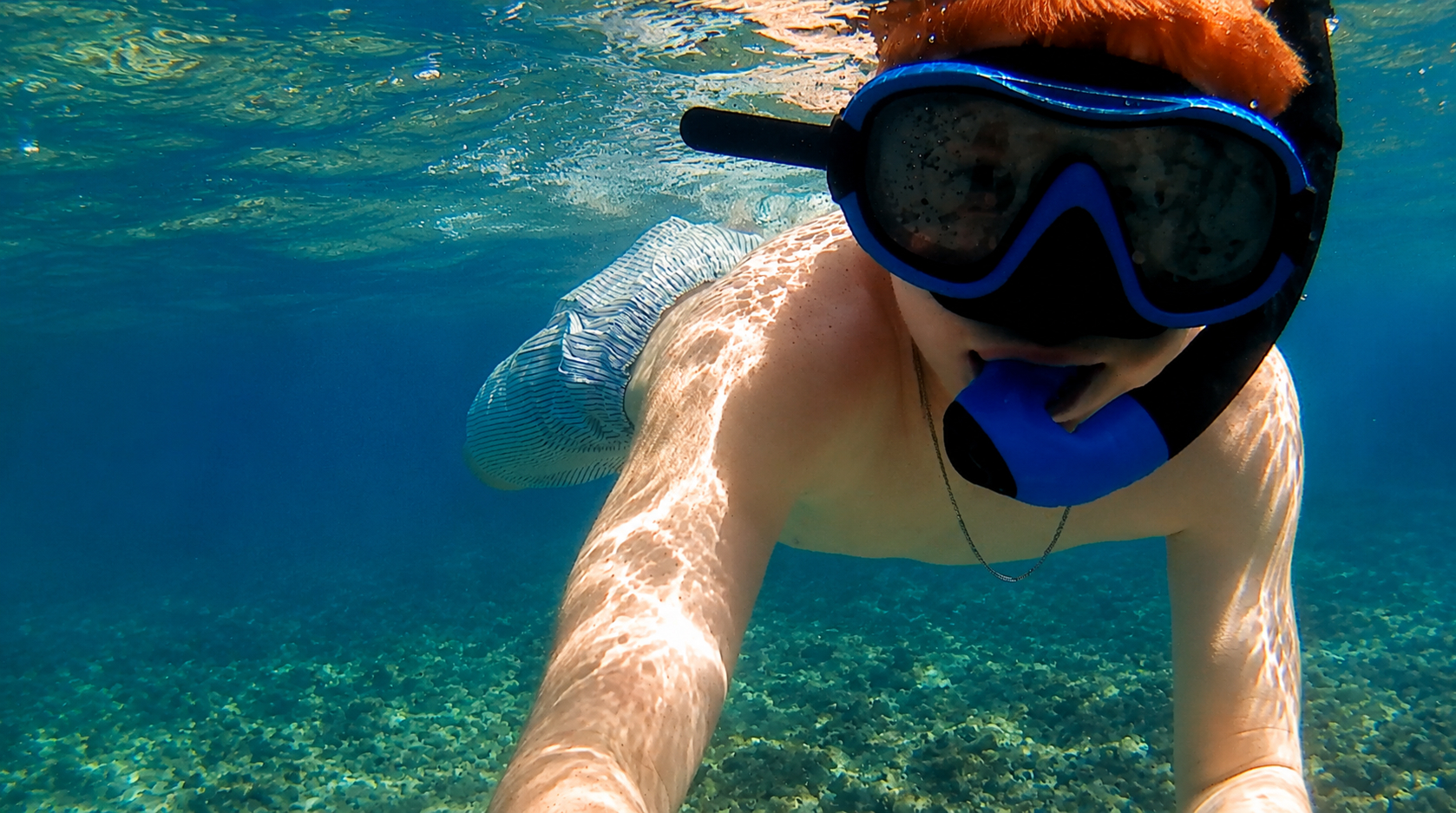 Guest with mask and snorkel exploring the shallows