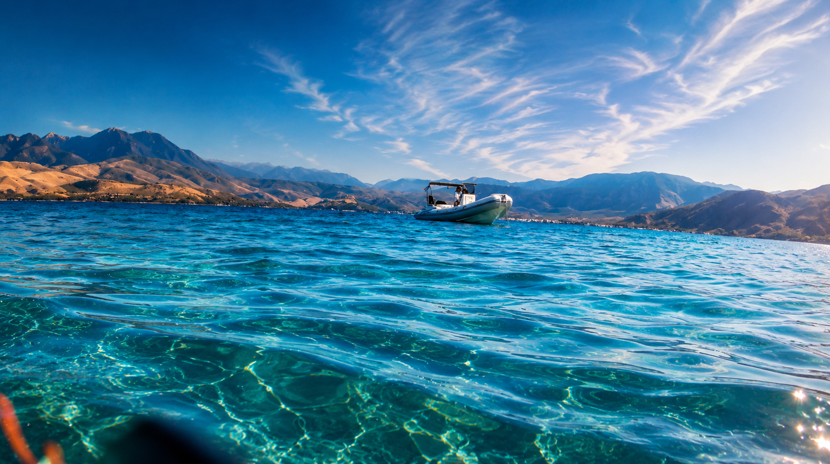 Re:Connect RIB drifting on crystal clear water with mountains behind