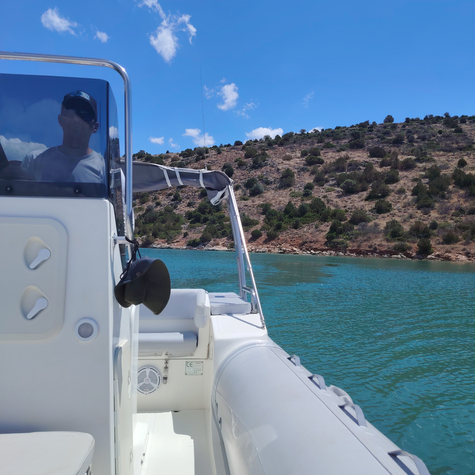 Skipper cruising past a rocky Fokida cove