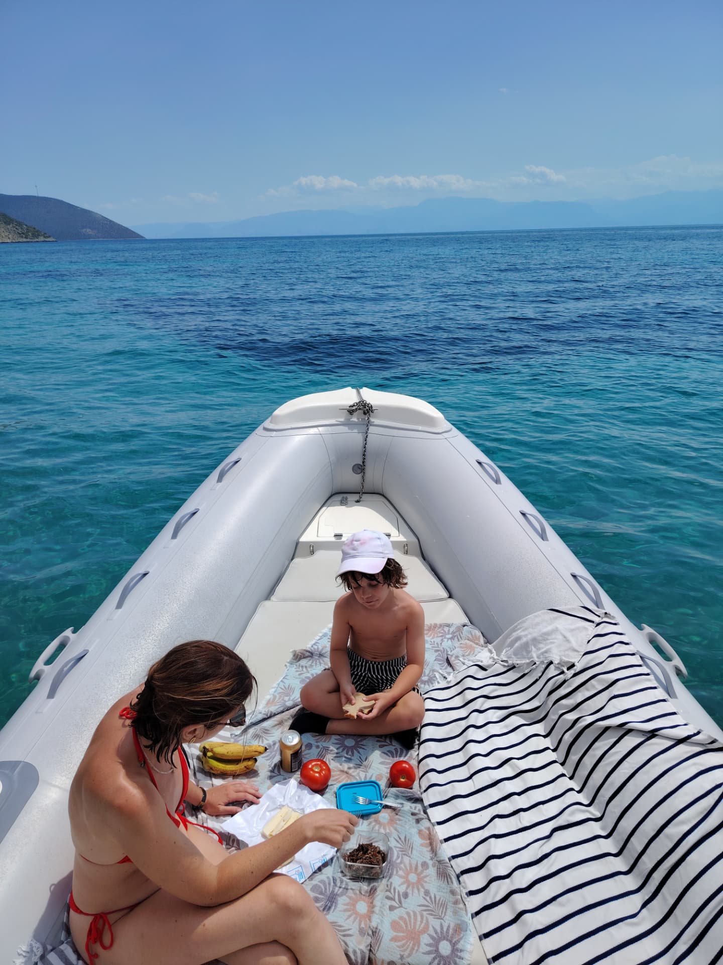 On-board picnic on the bow with turquoise sea behind