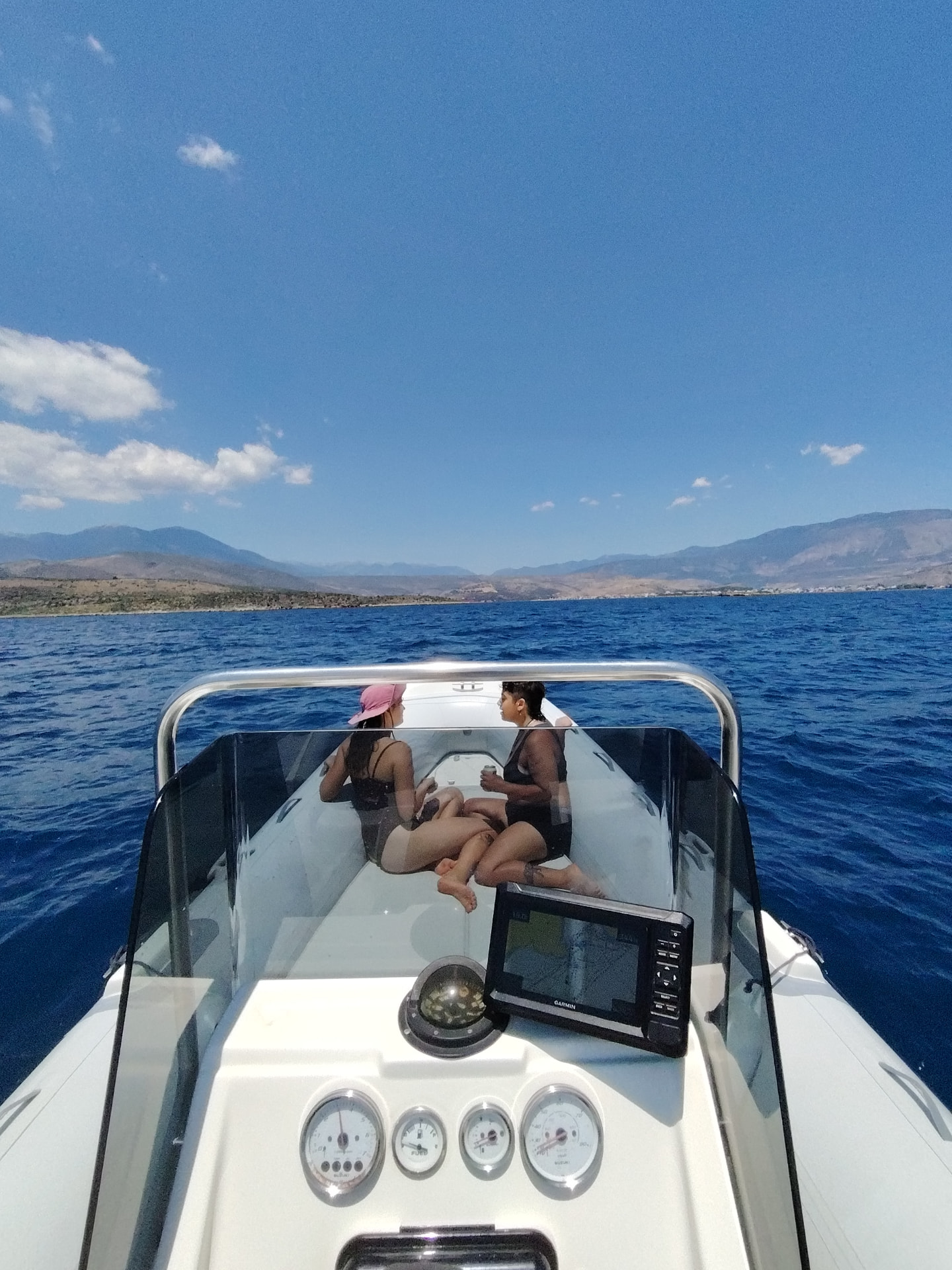 Two guests sitting on the bow with mountains behind