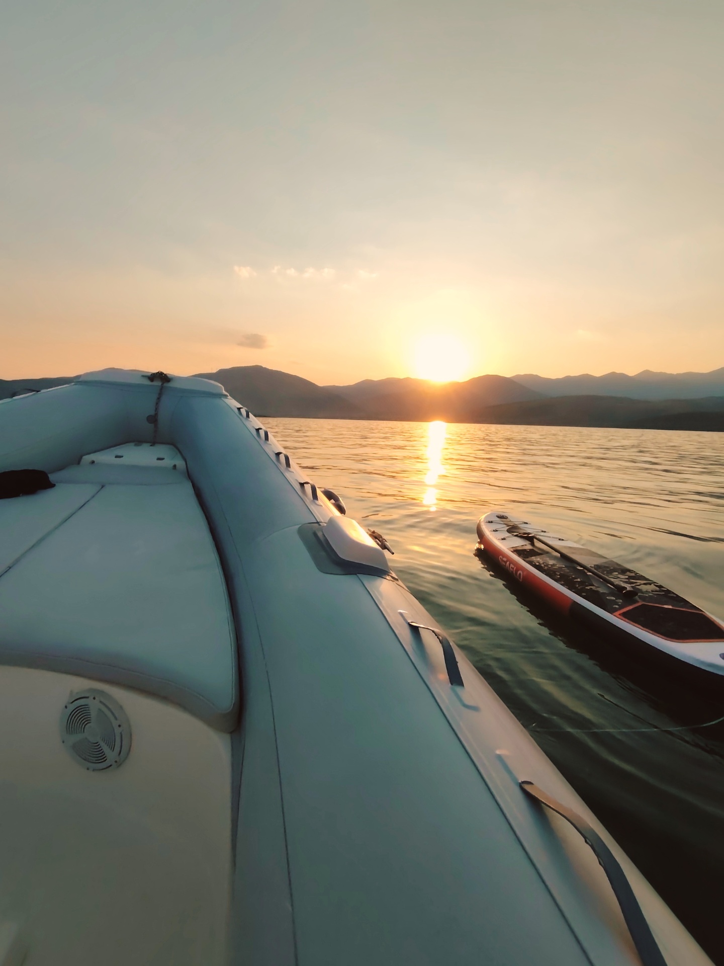 SUP paddleboard floating next to the Re:Connect RIB at sunset over the Gulf of Corinth