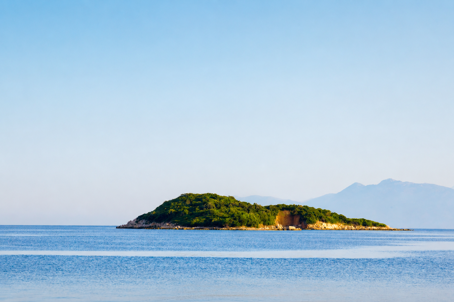 Aerial view of the Gulf of Corinth near Itea with a small boat anchored by a historical islet