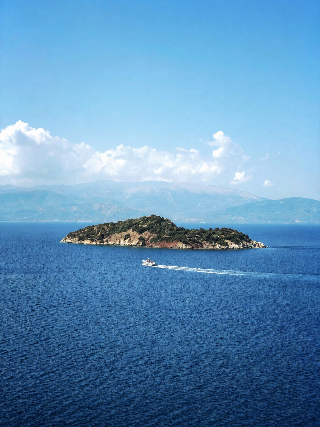 Boat passing a small island in the Gulf of Corinth