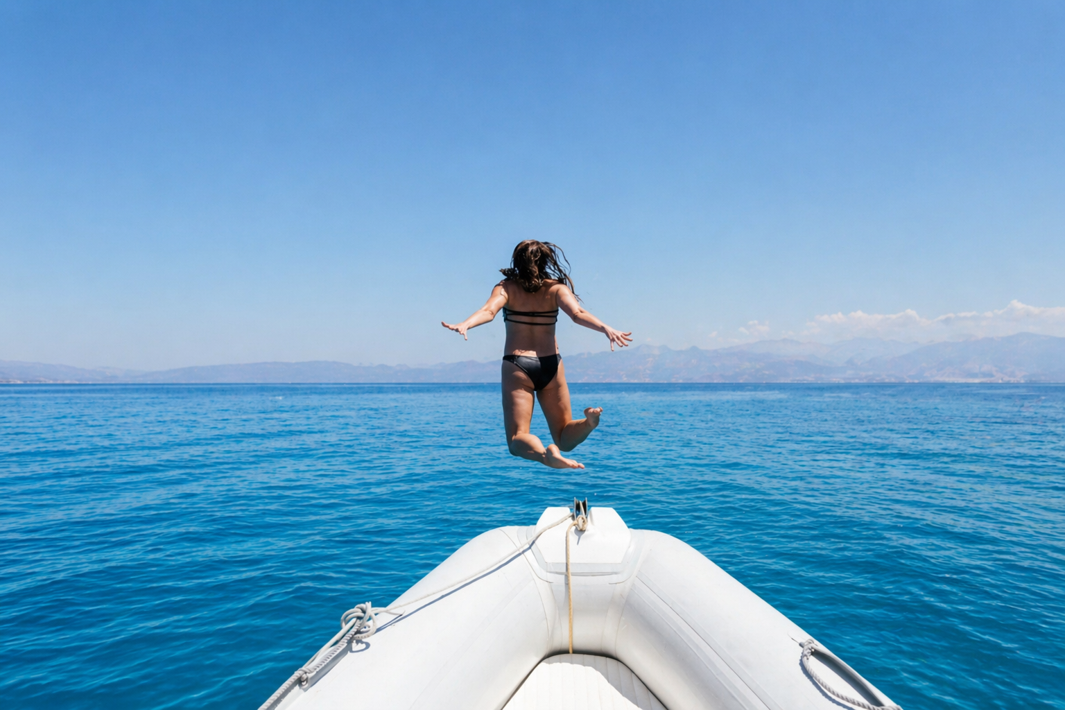 Guest jumping off the bow into the blue waters of Itea